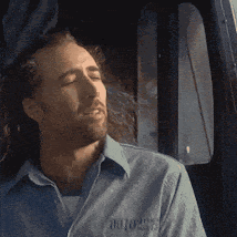 a man wearing a blue shirt with the word motors on the front