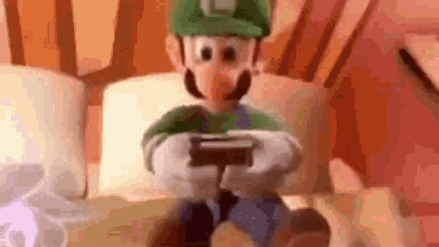 a close up of a toy mario playing a video game on a bed .