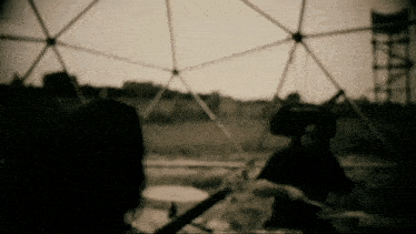 a black and white photo of a dome with a person playing drums in the foreground