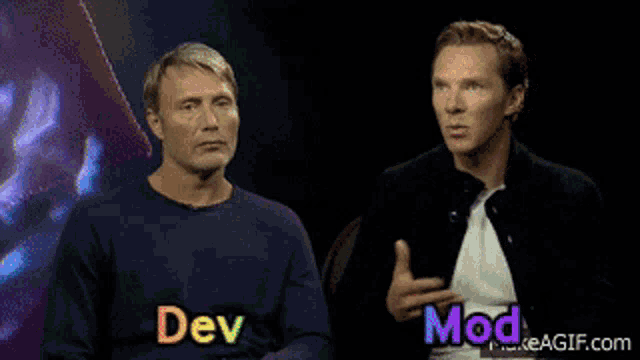 two men are sitting next to each other and the words dev and mod are on the screen