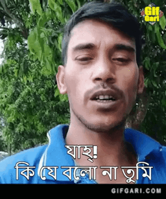 a man in a blue shirt is making a funny face in a foreign language .