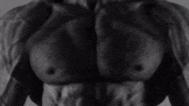 a black and white photo of a muscular man 's torso .