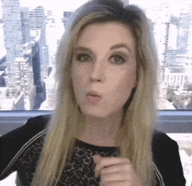 a woman is making a funny face in front of a city skyline