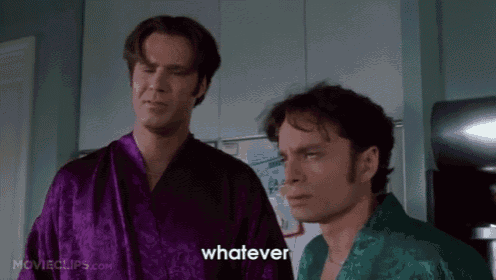 two men in purple robes are standing next to each other in a kitchen and one of them is saying whatever .