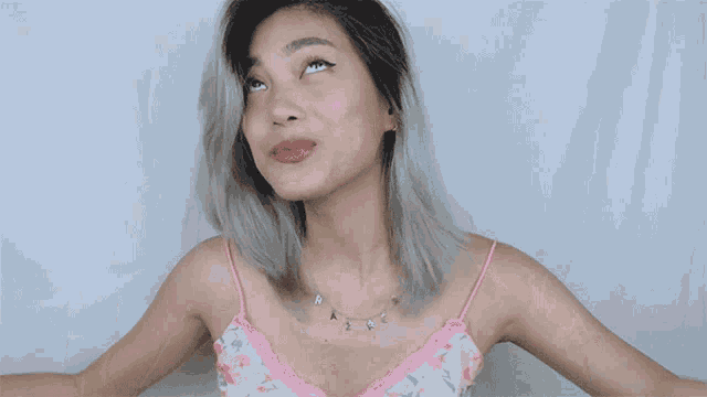 a woman wearing a pink tank top and a necklace that says " a2 " on it