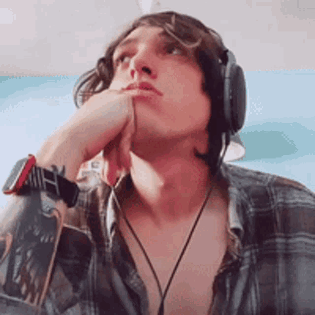 a man wearing headphones and a watch looks up at something