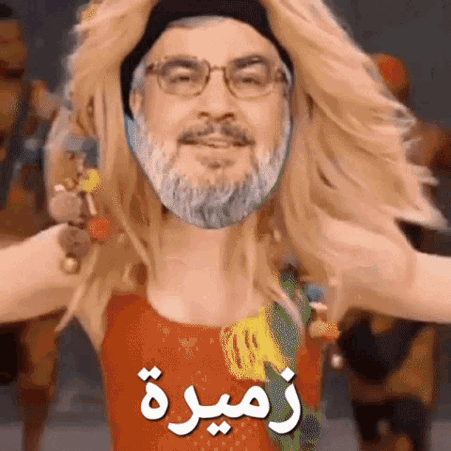 a man with a beard and glasses is wearing a wig and a hat .
