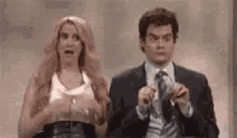 a man and a woman are standing next to each other on a stage .