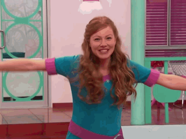 a woman with her arms outstretched is wearing a blue shirt