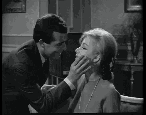 a black and white photo of a man kissing a woman