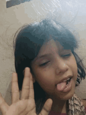 a girl sticking her tongue out while making a face