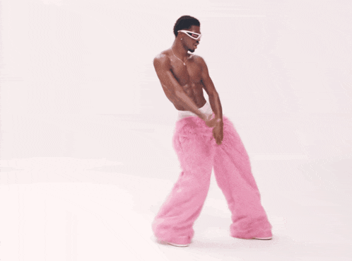 a man without a shirt is wearing pink pants and sunglasses