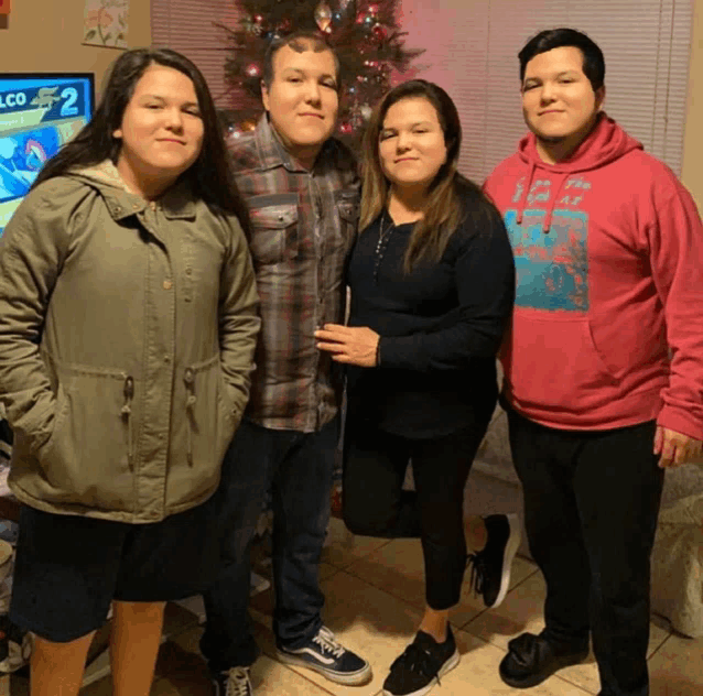 a family posing for a picture in front of a tv that says lco