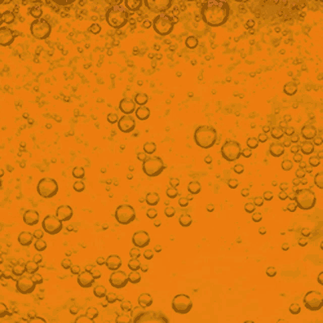 bubbles are floating in a yellow liquid