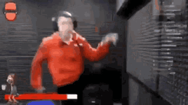 a man in a red shirt is playing a video game in a dark room .