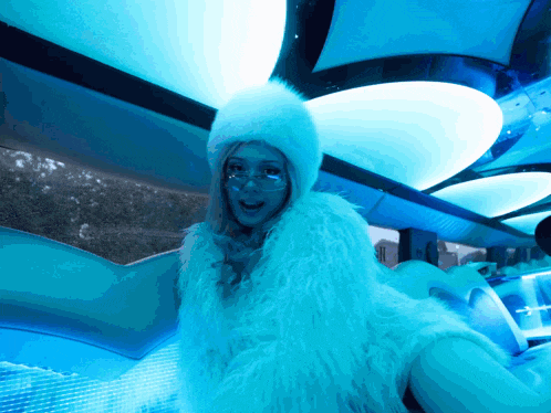 a woman wearing a white fur coat and a white fur hood