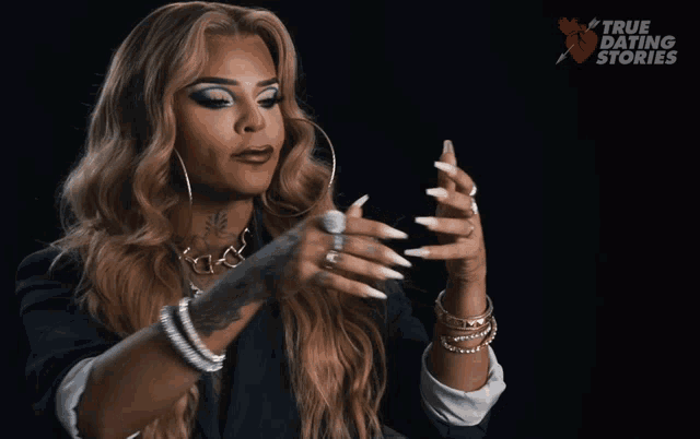 a woman wearing a necklace that says vinny holds her hand up