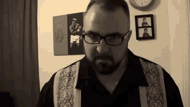 a man with glasses and a beard looks at the camera
