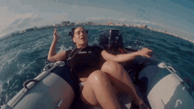 a woman is sitting in a boat with the word motor on the front