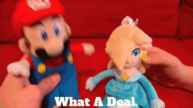 a mario and rosalina stuffed animal are being held by a person