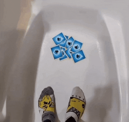 a person wearing a pair of pikachu socks holds a card with a lightning bolt on it