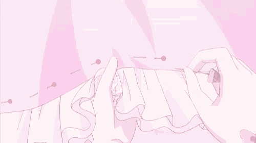 a person is sewing a pink dress with a pink ribbon .