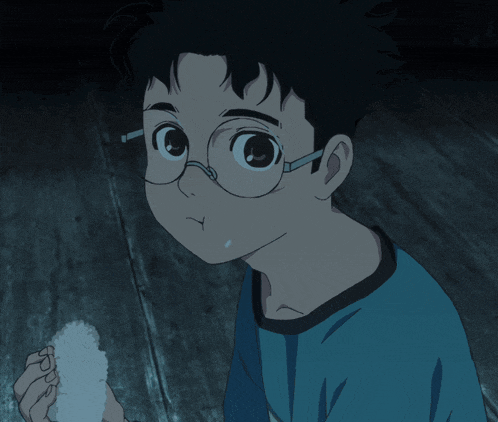a boy wearing glasses and a blue shirt is holding something