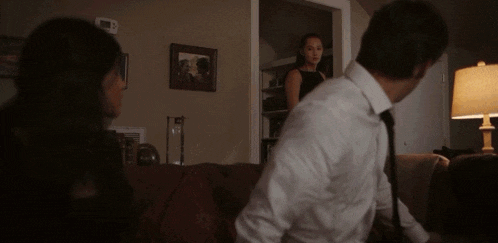 a man in a white shirt and tie is standing in front of a woman in a black dress