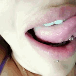 a close up of a woman 's mouth with her tongue sticking out