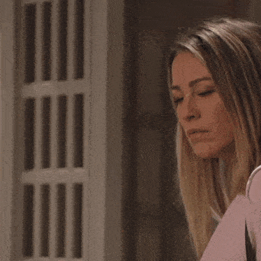 a woman in a pink sweater is looking down