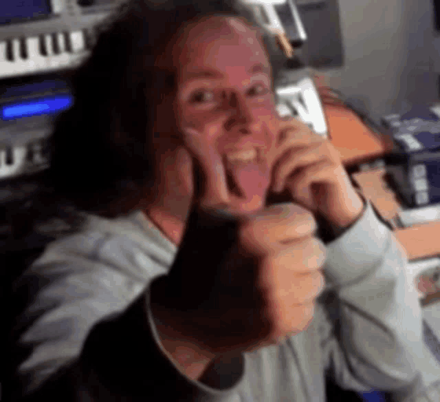 a man is sticking his tongue out and giving a thumbs up sign