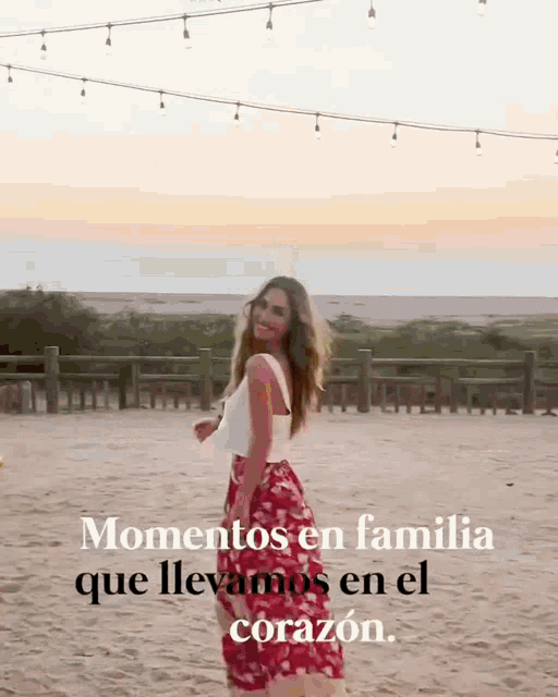 a woman in a red skirt is standing on a beach with the words " momentos en familia que llevamos en el corazon "