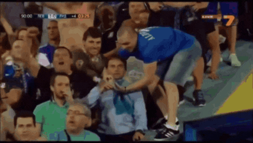 a man in a blue shirt with the word liberty on it stands in a crowd