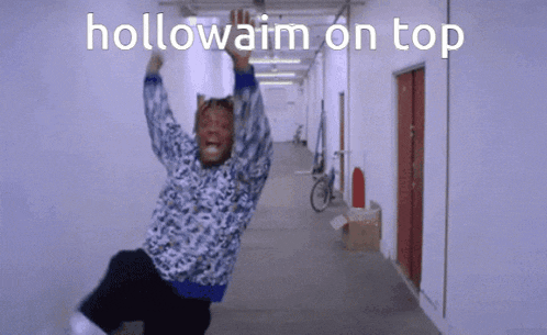 a man is hanging upside down in a hallway with the words hollowaim on top behind him