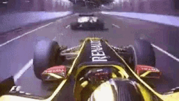 a yellow and black renault race car is driving down a race track .