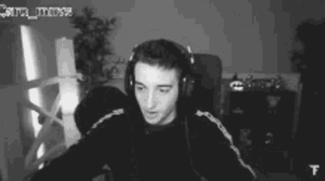a man wearing headphones is sitting in front of a computer screen .
