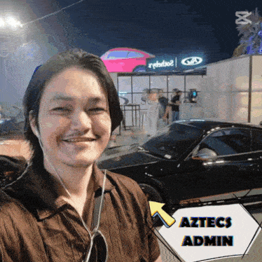 a man standing in front of a car with aztecs admin on the bottom