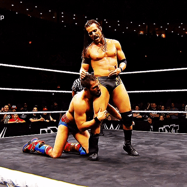 a man in a wrestling ring with the letter p on the bottom left