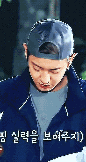 a man wearing a baseball cap and a jacket with korean writing