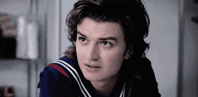a close up of a young man wearing a sailor 's uniform