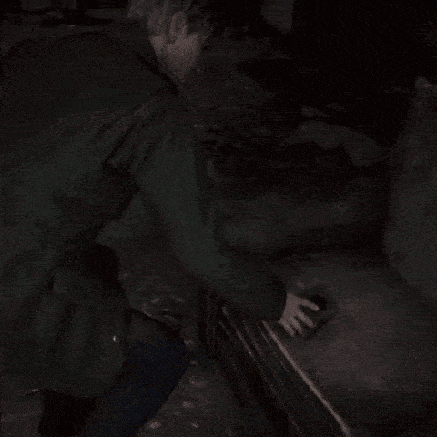 a man in a dark room with the number 12 on the wall behind him