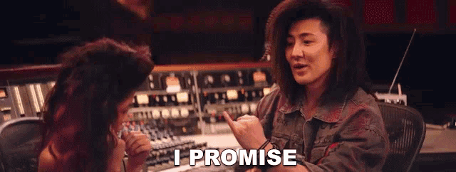 a woman with long hair is talking to another woman in a recording studio and the woman is saying i promise