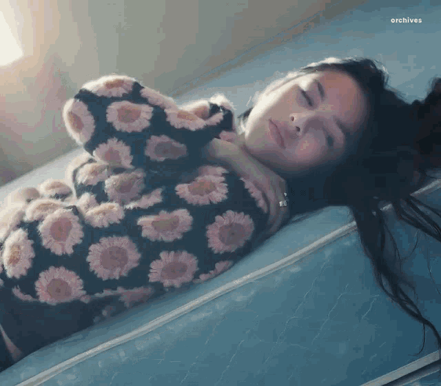a woman is laying on a mattress with her eyes closed and the words archives below her