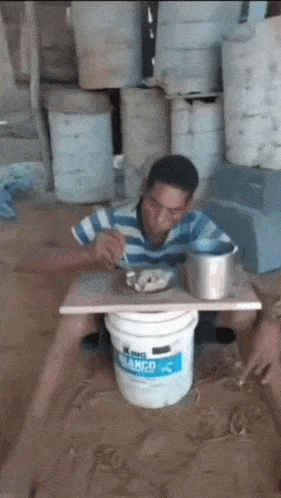 a man is sitting in a bucket of king blanco paint