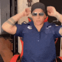 a man wearing a police uniform and sunglasses is sitting in a chair .