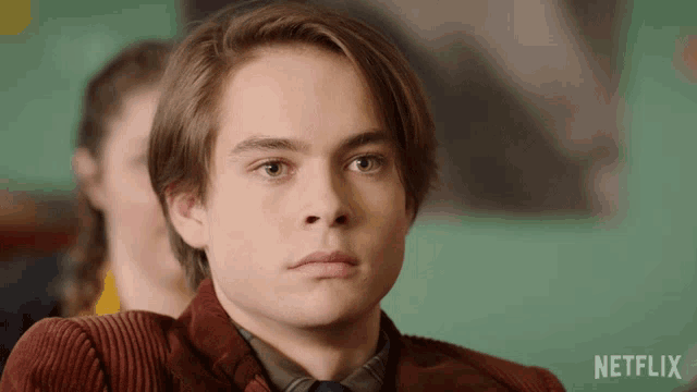 a young man sitting in a classroom with a netflix logo on the bottom right