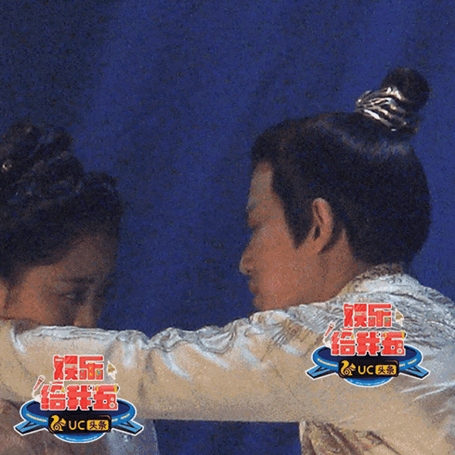 a man and a woman are hugging with uc written on the bottom right