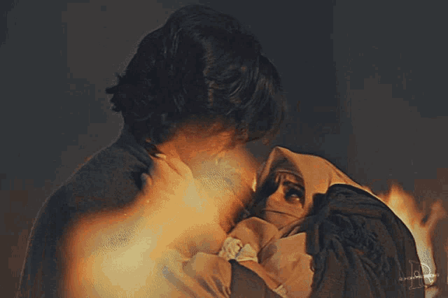 a man and a woman are hugging each other with the letter b on the bottom left