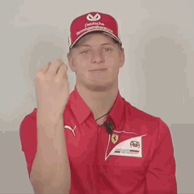 a man wearing a red shirt and a red hat with deutsche written on it