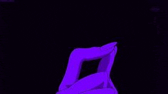 a person is making a heart shape with their hands in a dark room .